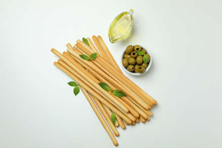 Grissini with basil, olives and oil on white backgroundの写真素材