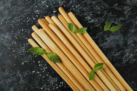Grissini breadsticks with salt and basil on black smoky backgroundの写真素材