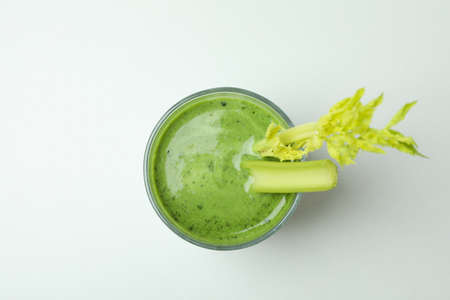 Glass of green smoothie with celery on white backgroundの写真素材