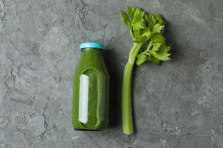 Bottle of green smoothie and celery on gray backgroundの写真素材