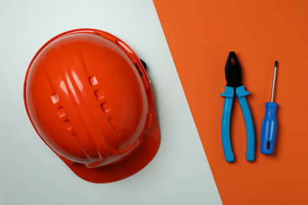 Hard hat and tools on two tone background, top viewの写真素材