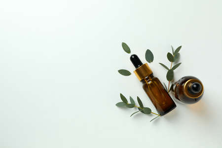 Brown bottles of eucalyptus oil and twigs on white backgroundの写真素材
