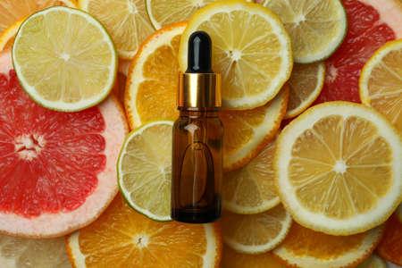 Dropper bottle with oil on different citrus slicesの写真素材