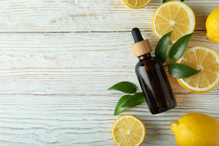 Dropper bottle with oil and lemons on white wooden tableの写真素材