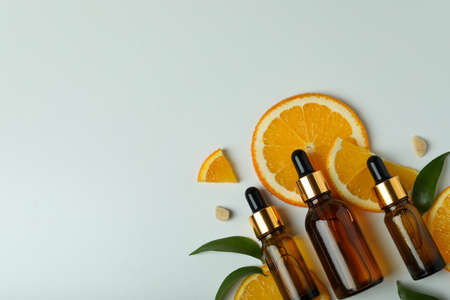 Dropper bottles with oil and orange slices on white backgroundの写真素材