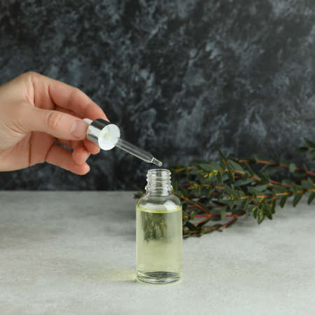 Concept of natural cosmetics with female hand dripping eucalyptus oil