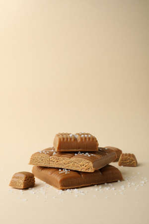 Salted caramel pieces on beige background, space for textの写真素材