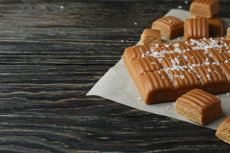 Baking paper with salted caramel pieces on wooden backgroundの写真素材