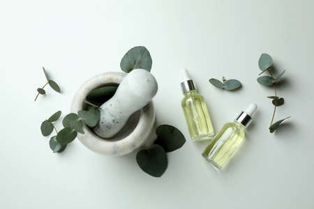 Mortar with eucalyptus and dropper bottles of oil on white backgroundの写真素材