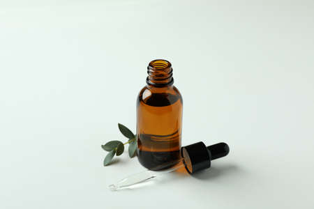 Brown bottle of eucalyptus oil and twig on white backgroundの写真素材
