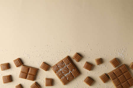 Salted caramel pieces on beige background, space for textの写真素材