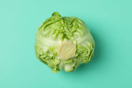 Fresh green cabbage on mint background, close up