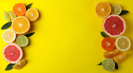 Ripe citrus on yellow background, space for text
