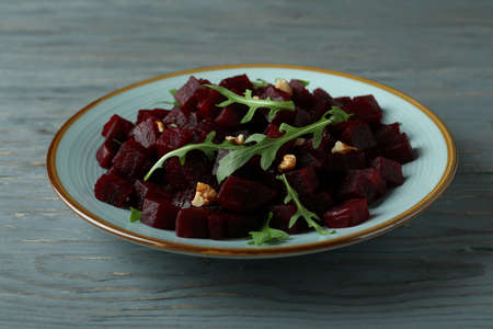 Bowl with fresh beet salad on wooden table