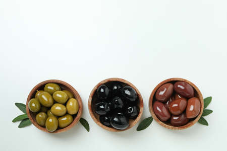 Wooden bowls of olives and leaves on white backgroundの写真素材