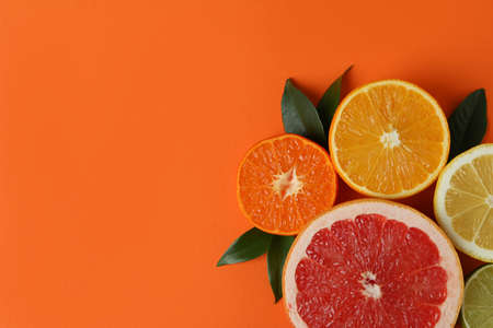 Ripe citrus with leaves on orange background