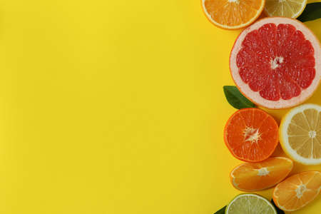Ripe citrus on yellow background, space for text