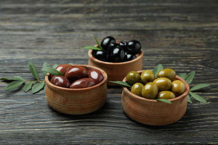 Bowls of different olives on wooden backgroundの写真素材
