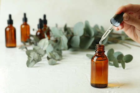 Concept of natural cosmetics with female hand dripping eucalyptus oilの写真素材