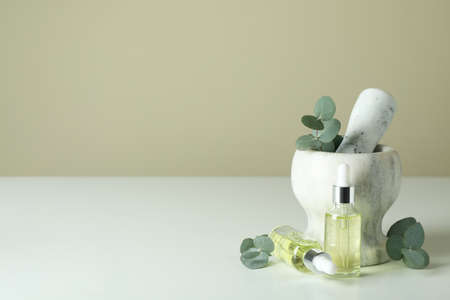 Mortar with eucalyptus and dropper bottles of oil on white tableの写真素材