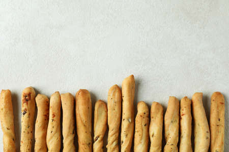 Tasty grissini breadsticks on white textured backgroundの写真素材
