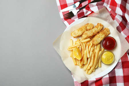 Concept of tasty eating with fried fish and chips on gray backgroundの写真素材