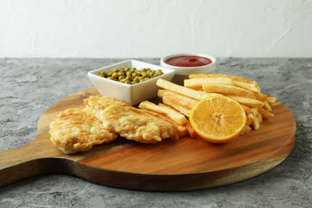 Concept of tasty eating with fried fish and chips on gray textured backgroundの写真素材
