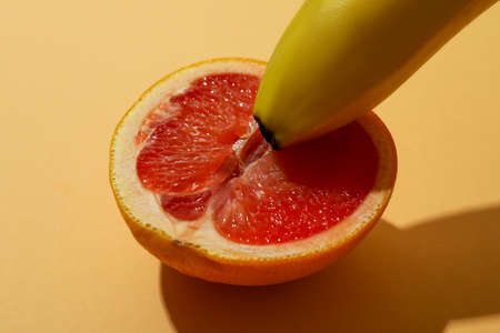Banana and grapefruit on beige background, close upの写真素材