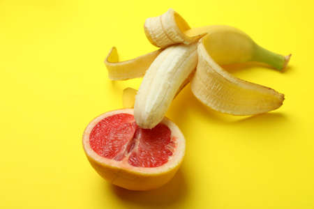 Banana with grapefruit half on yellow backgroundの写真素材