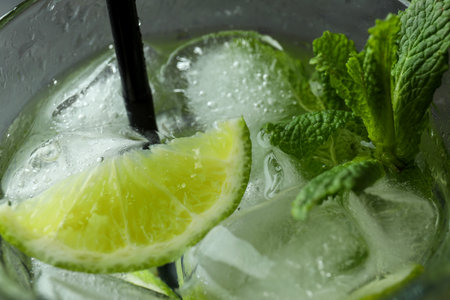 Glass of mojito cocktail with straw, close up