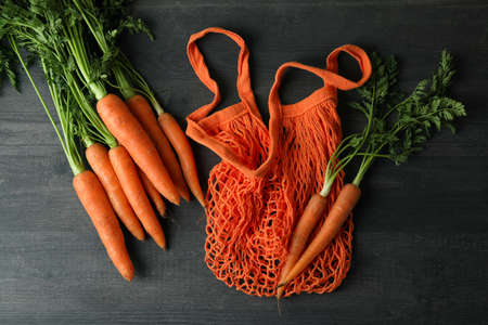 String bag and carrot on dark wooden backgroundの写真素材