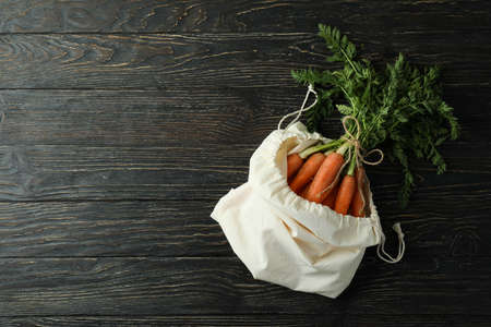 Bag with fresh carrot on wooden backgroundの写真素材