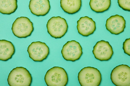Fresh ripe cucumber slices on mint backgroundの写真素材