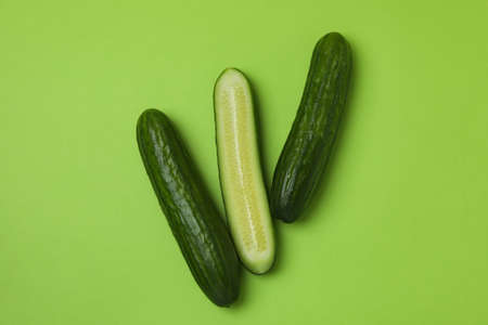 Three fresh ripe cucumbers on green backgroundの写真素材