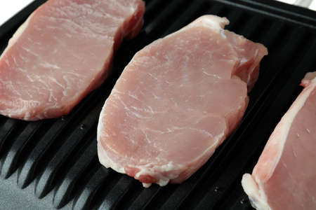 Electric grill with raw steak, close up