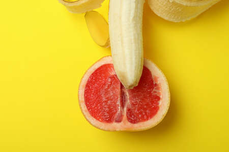 Banana with grapefruit half on yellow backgroundの写真素材