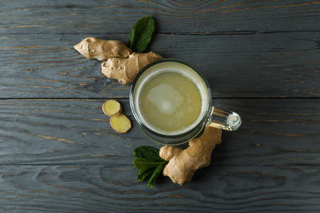 Glass of ginger beer and ingredients on wooden tableの写真素材