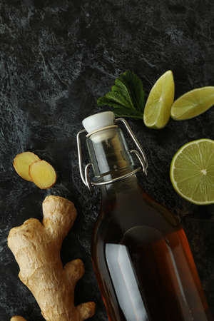 Bottle of ginger beer and ingredients on black smoky backgroundの写真素材