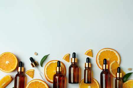 Dropper bottles with oil and orange slices on white backgroundの写真素材