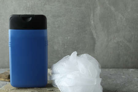 Bottle of shower gel and washcloth on gray textured tableの写真素材