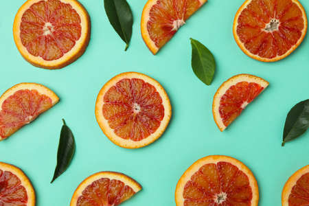 Red orange slices and leaves on mint backgroundの写真素材
