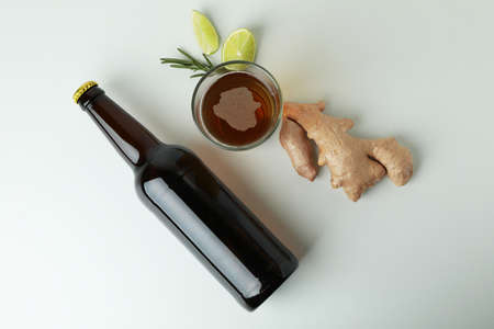 Glass and bottle of ginger beer, and ingredients on white backgroundの写真素材