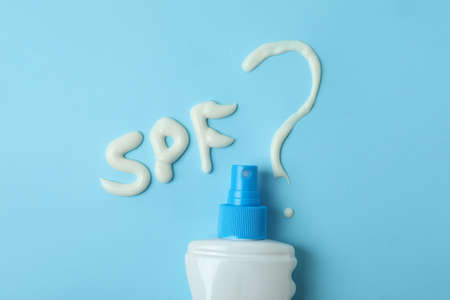 Text SPF? and sunscreen on blue background
