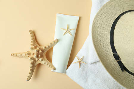 Sea accessories and sunscreen on beige background