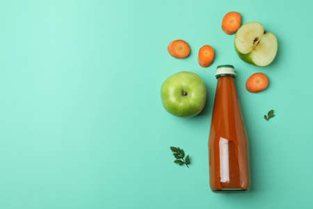 Bottle of juice and ingredients on mint backgroundの写真素材