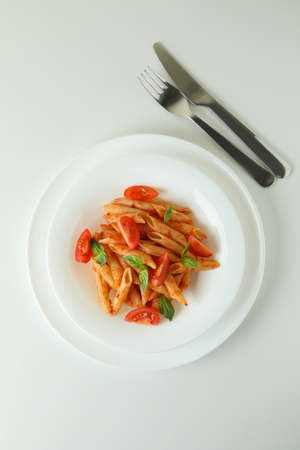 Plate with pasta with tomato sauce on white background