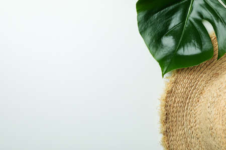 Straw hat and palm leaf on white backgroundの写真素材