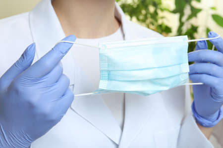 Doctor in medical gloves hold mask, close up