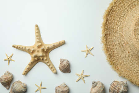 Straw hat and seashells on white backgroundの写真素材