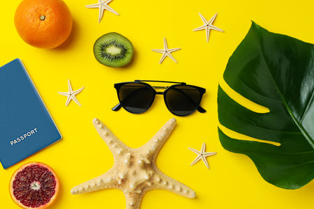 Summer accessories on yellow background, top view